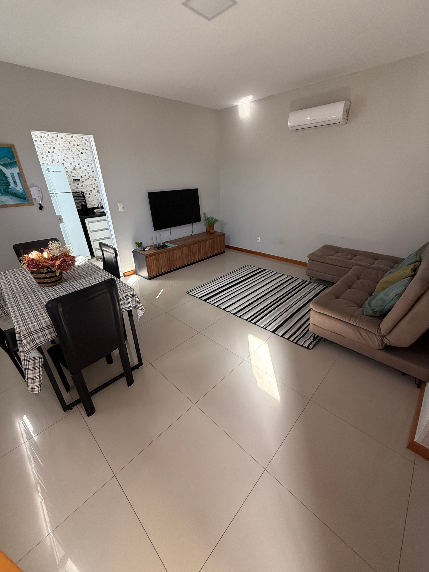 Sala de estar ampla com TV e mesa de jantar